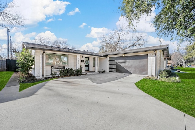 ranch-style home featuring a garage and a front lawn