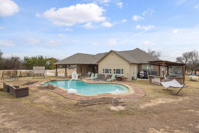 view of pool featuring pool water feature, a patio area, and an outdoor bar