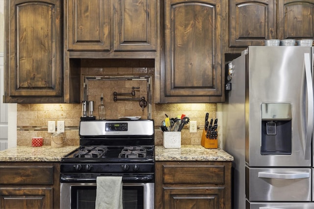 kitchen with decorative backsplash, dark brown cabinets, light stone counters, and stainless steel appliances