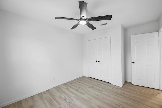 unfurnished bedroom featuring light hardwood / wood-style floors, a closet, and ceiling fan