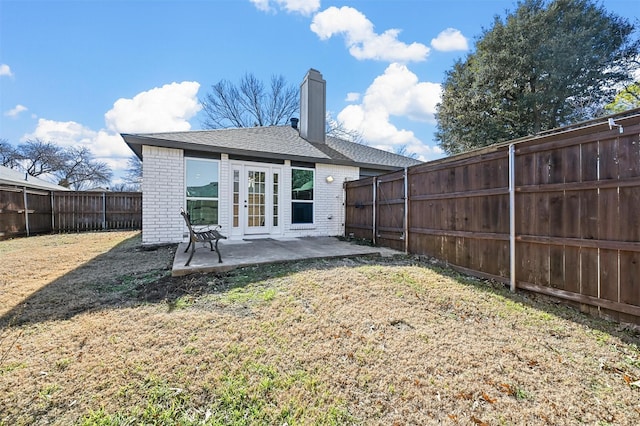 back of property with a patio area, a yard, and french doors