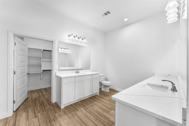 bathroom featuring hardwood / wood-style flooring, vanity, and toilet