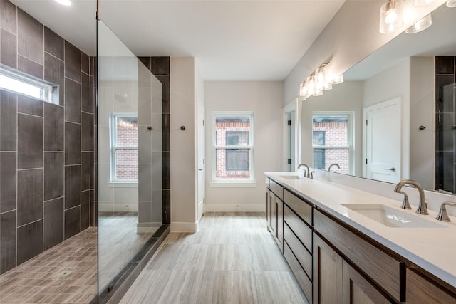 bathroom featuring plenty of natural light, vanity, and a tile shower