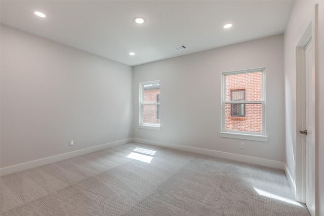 spare room with light colored carpet and a healthy amount of sunlight