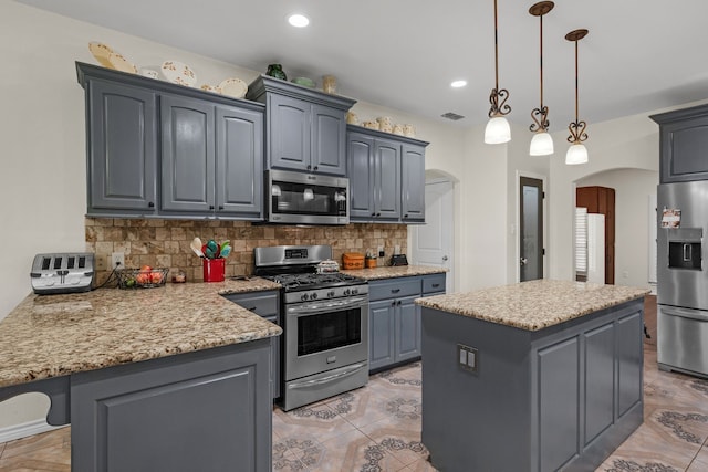 kitchen featuring decorative backsplash, stainless steel appliances, and a kitchen island