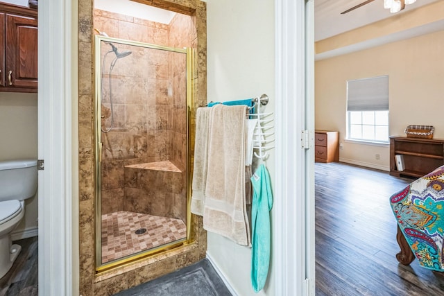 bathroom with an enclosed shower, ceiling fan, and toilet