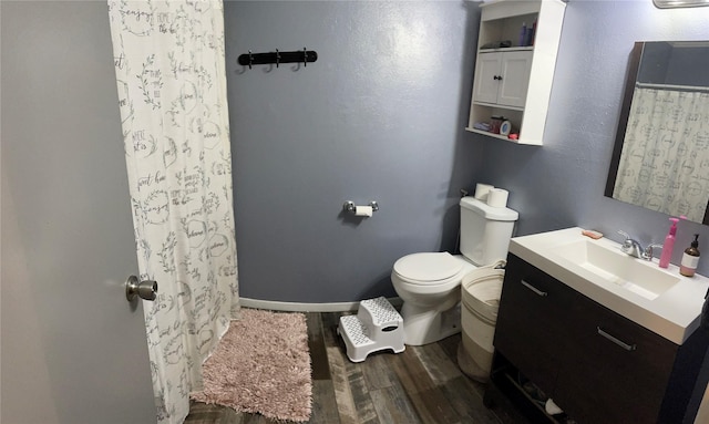 bathroom with toilet, wood-type flooring, and vanity