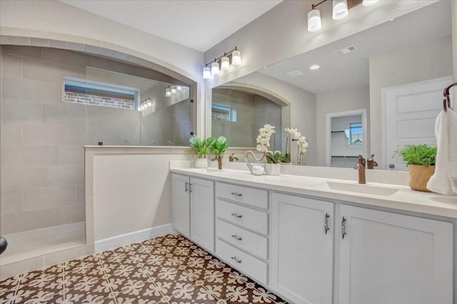 bathroom featuring tile patterned floors, vanity, and tiled shower