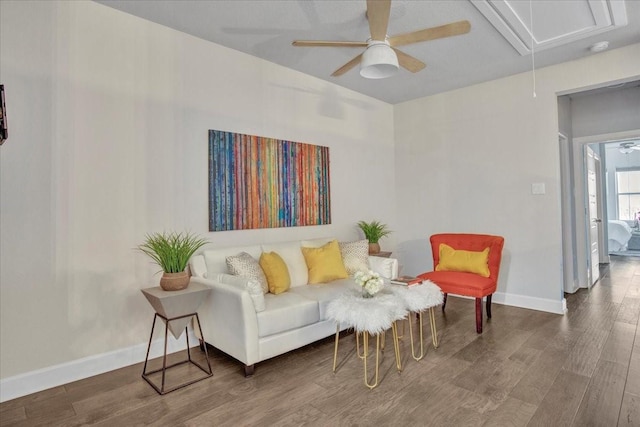 sitting room with ceiling fan and wood-type flooring