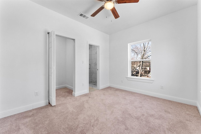 unfurnished bedroom featuring light colored carpet, ceiling fan, and ensuite bath