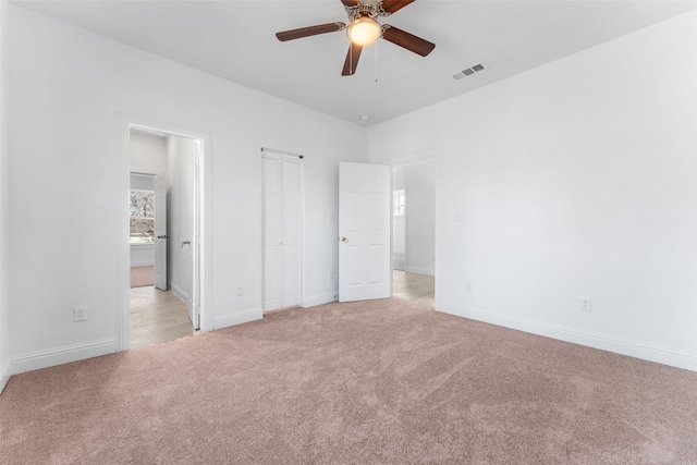 unfurnished bedroom featuring light colored carpet and ceiling fan