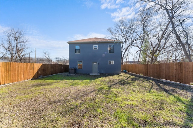 back of property with central AC and a yard