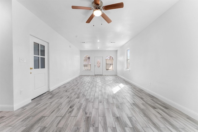 unfurnished living room featuring ceiling fan and light wood-type flooring