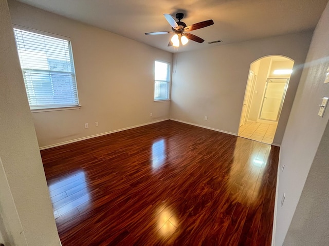 unfurnished room with ceiling fan and dark hardwood / wood-style flooring