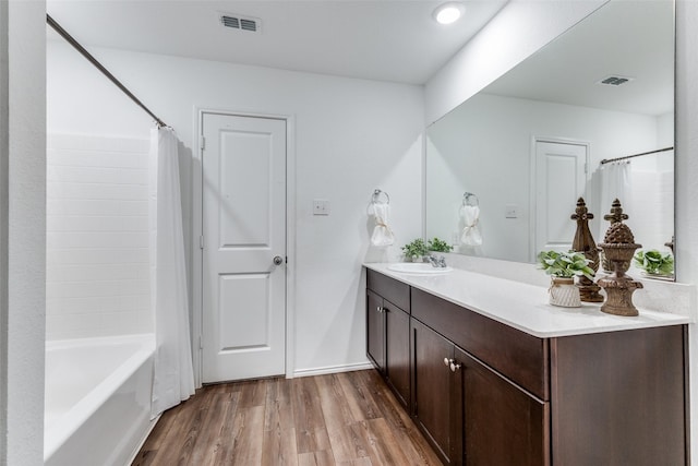 bathroom with wood-type flooring, vanity, and shower / tub combo with curtain