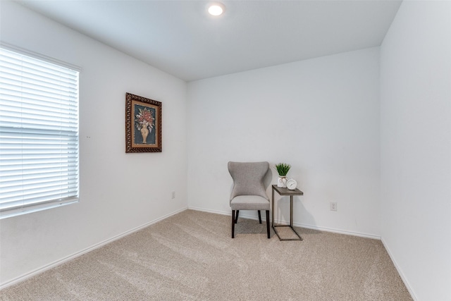 sitting room featuring light colored carpet