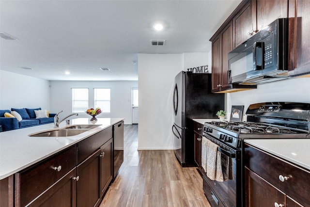 kitchen with light wood-type flooring, sink, dark brown cabinetry, and black appliances