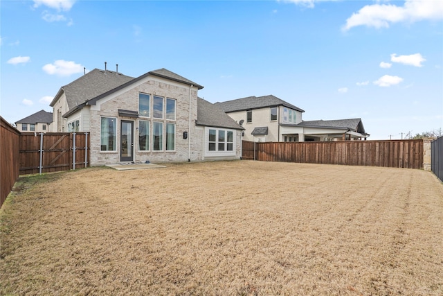 rear view of property featuring a lawn