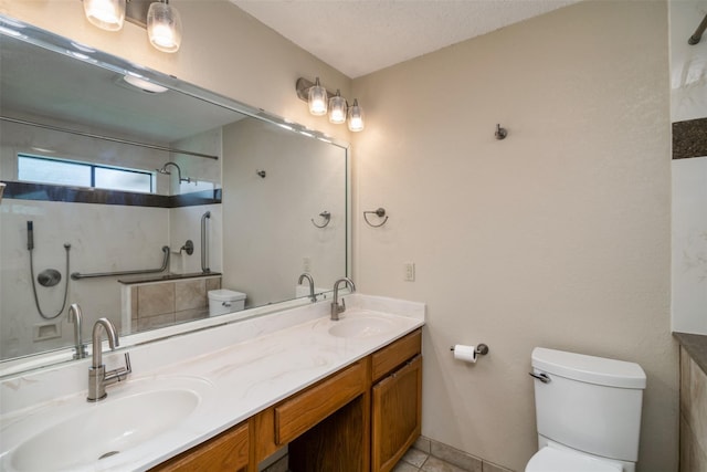 bathroom featuring a textured ceiling, toilet, and vanity