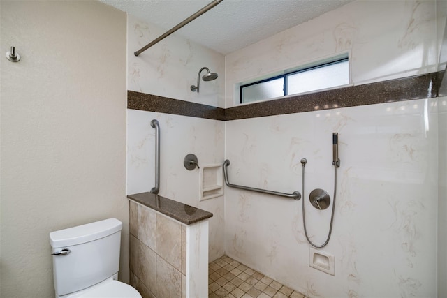 bathroom featuring a textured ceiling, toilet, and a tile shower