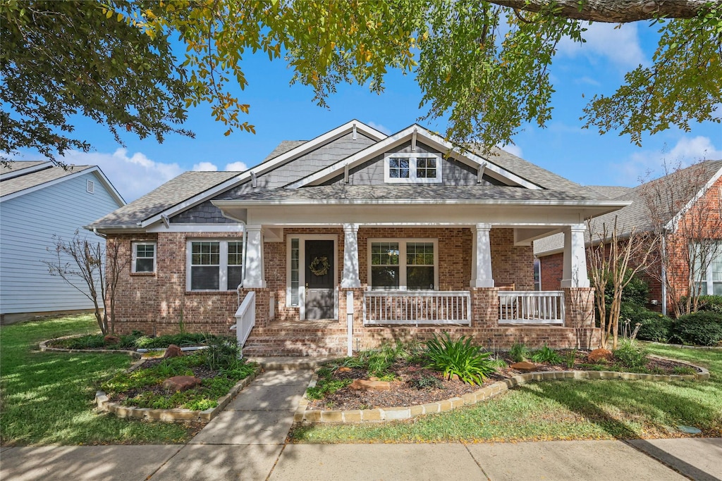 craftsman-style home featuring a front lawn and covered porch