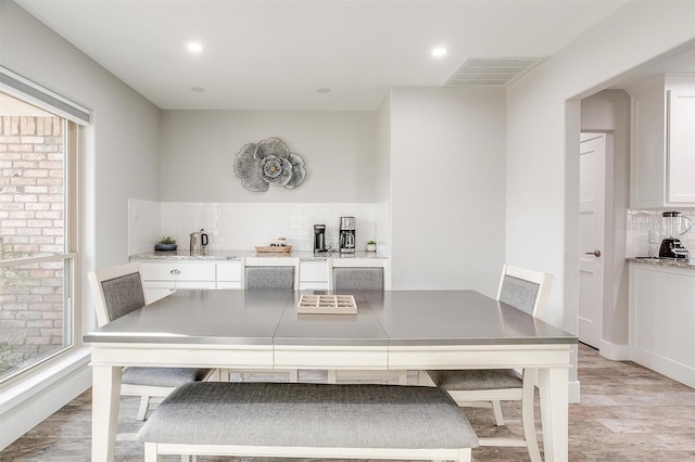 dining space with a healthy amount of sunlight and light hardwood / wood-style floors