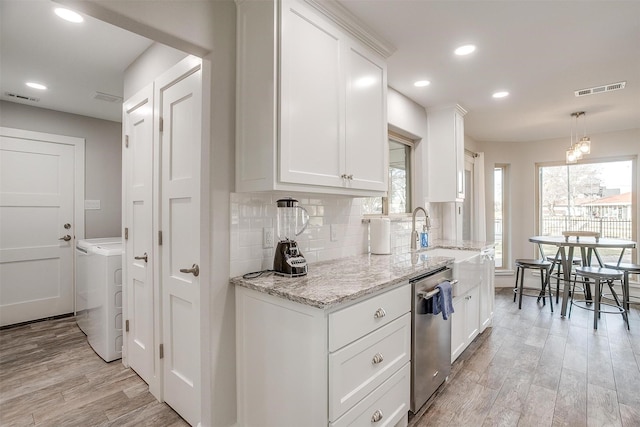 kitchen with stainless steel dishwasher, white cabinets, and light wood-type flooring