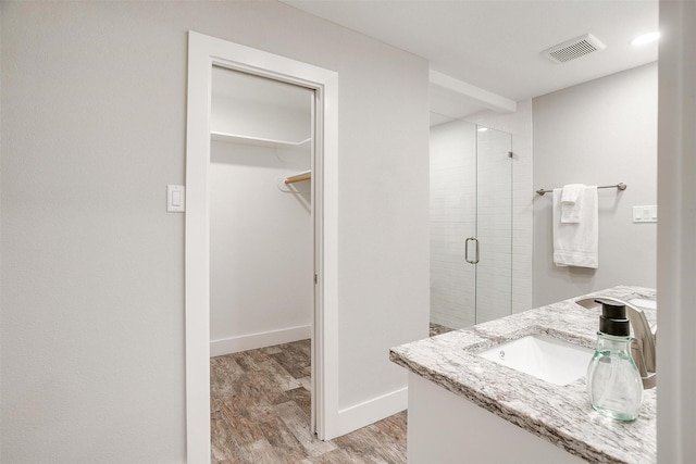 bathroom featuring an enclosed shower, vanity, and hardwood / wood-style flooring