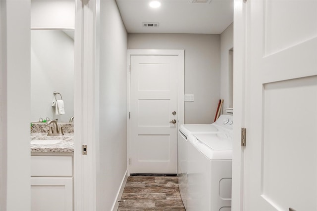 washroom featuring dark wood-type flooring, sink, and separate washer and dryer