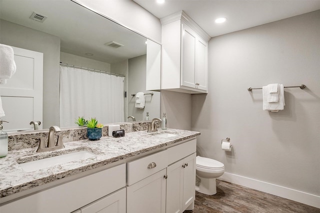 bathroom with wood-type flooring, toilet, and vanity