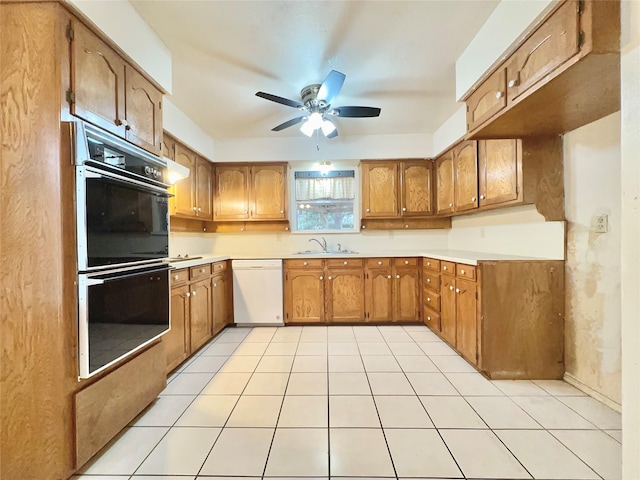 kitchen featuring double oven, light tile patterned floors, dishwasher, and sink