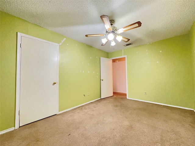 unfurnished bedroom featuring a textured ceiling, ceiling fan, and light carpet