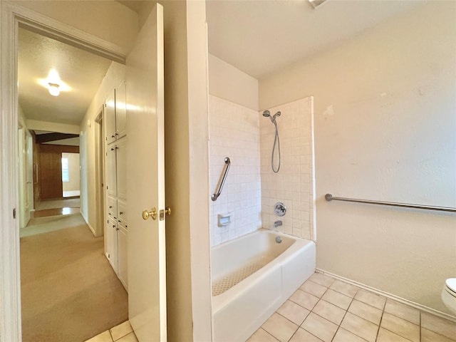 bathroom with toilet, tiled shower / bath, and tile patterned floors