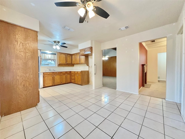 kitchen featuring ceiling fan, light tile patterned floors, and sink