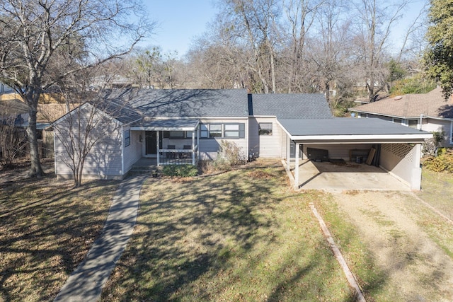 rear view of property with a lawn, a carport, and covered porch