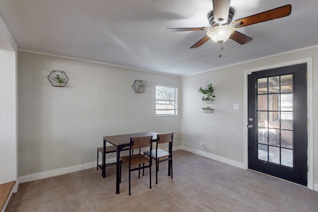 carpeted dining area featuring crown molding and ceiling fan