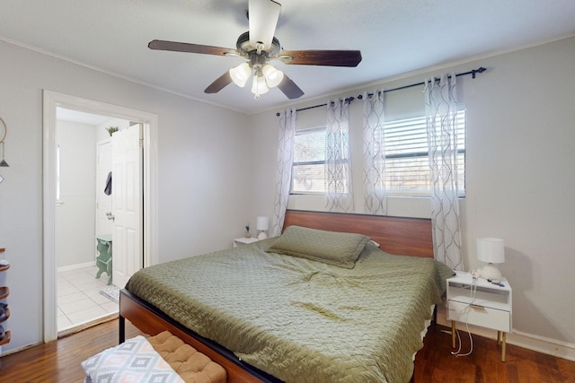 bedroom with ensuite bathroom, ornamental molding, dark wood-type flooring, and ceiling fan