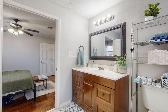 bathroom with ceiling fan, vanity, and a textured ceiling