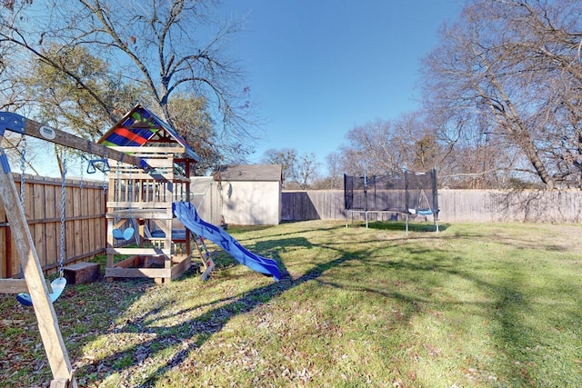 view of play area with a trampoline, a storage shed, and a lawn