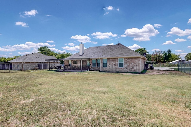 back of property with a lawn and a patio