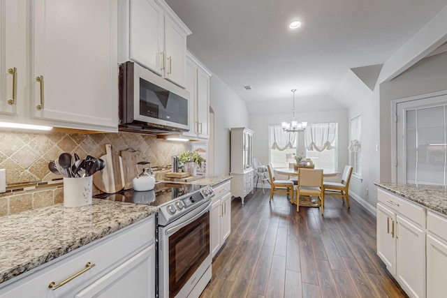 kitchen featuring white cabinetry, stainless steel appliances, tasteful backsplash, hanging light fixtures, and dark hardwood / wood-style floors