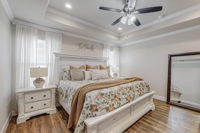 bedroom featuring ceiling fan, dark hardwood / wood-style floors, and a tray ceiling