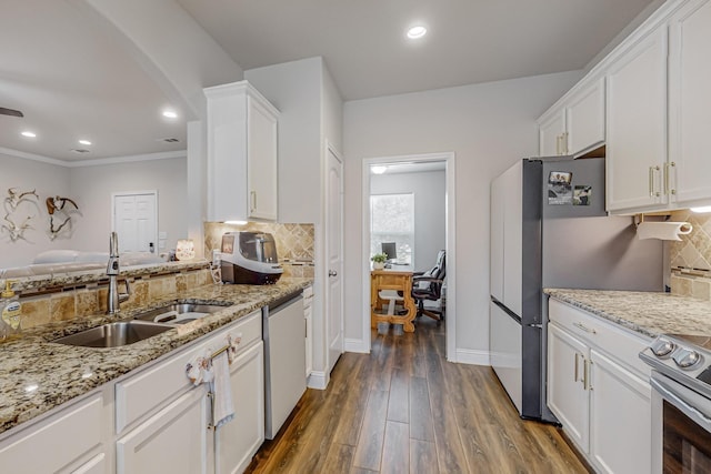 kitchen with tasteful backsplash, dark hardwood / wood-style floors, sink, appliances with stainless steel finishes, and white cabinets