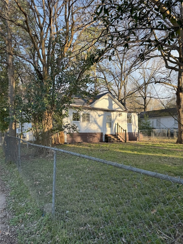view of property exterior with a lawn, brick siding, and fence private yard