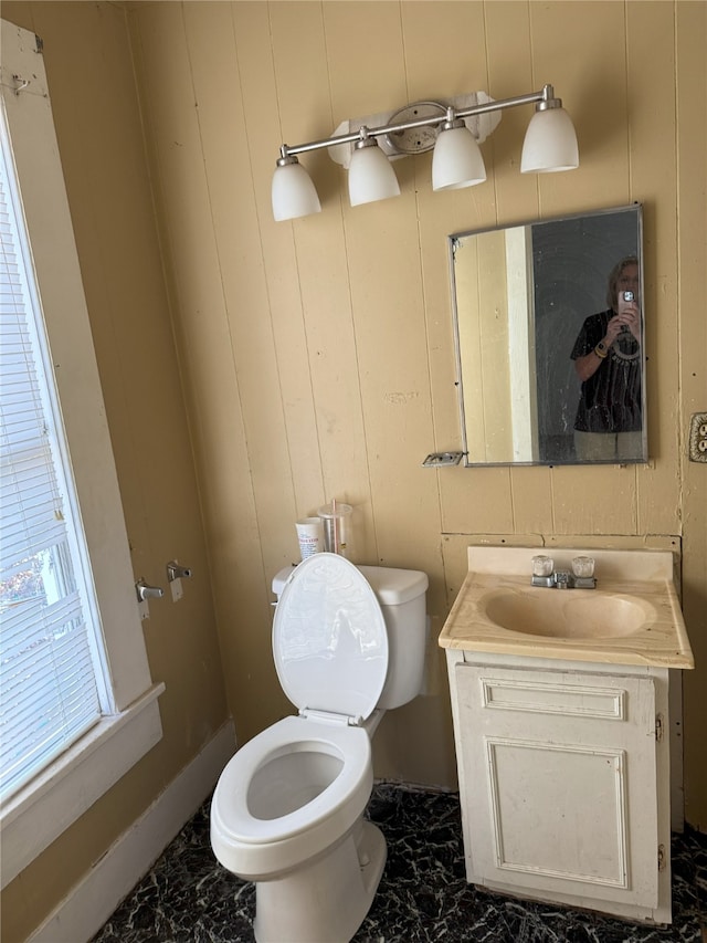 bathroom featuring toilet, marble finish floor, and vanity