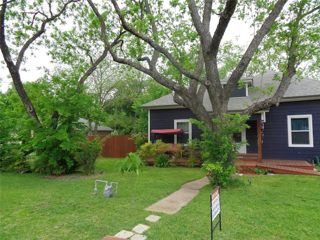 view of front of property featuring a wooden deck and a front yard