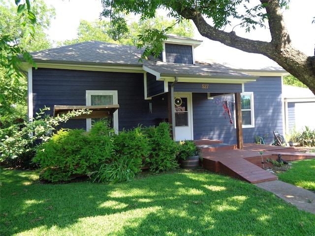 view of front facade featuring a wooden deck and a front yard