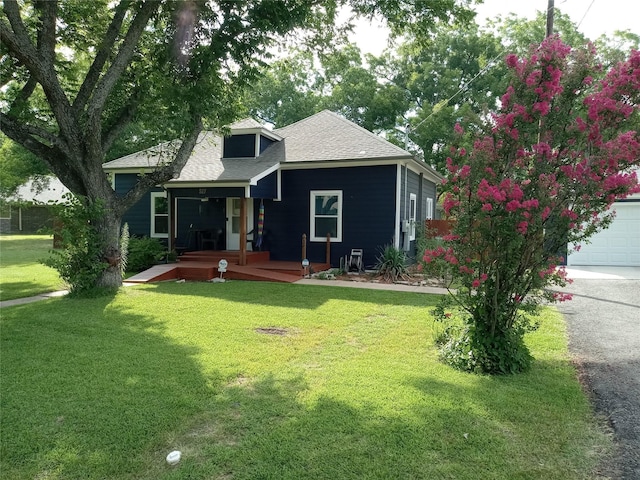 view of front of home featuring a front lawn, a garage, and a porch