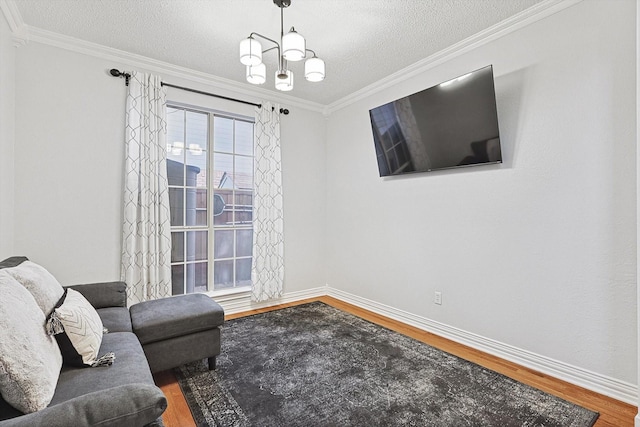 sitting room featuring hardwood / wood-style flooring, ornamental molding, and a textured ceiling