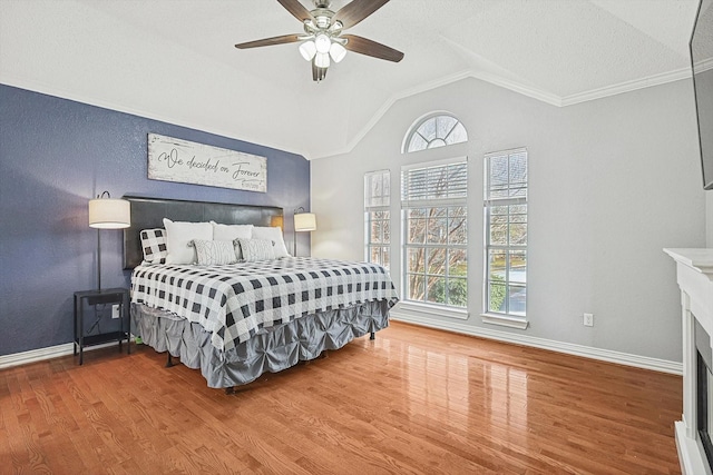 bedroom featuring hardwood / wood-style flooring, ceiling fan, vaulted ceiling, and multiple windows